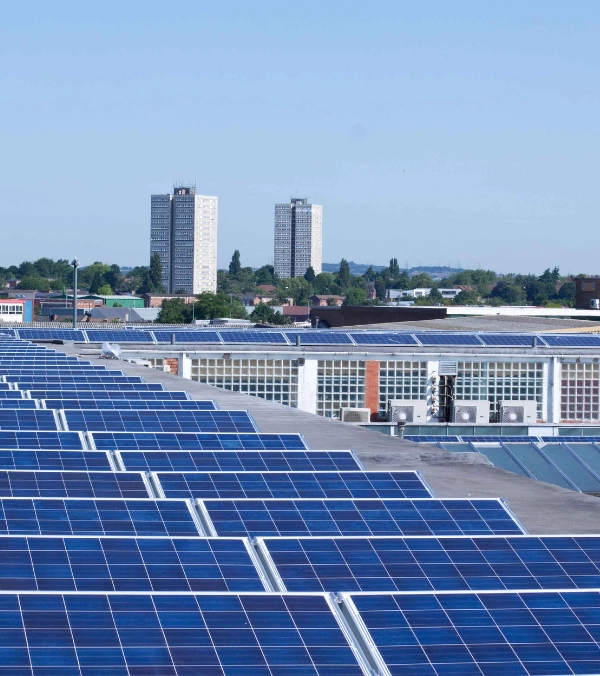 Paneles solares en techo industrial con vista urbana en Puebla