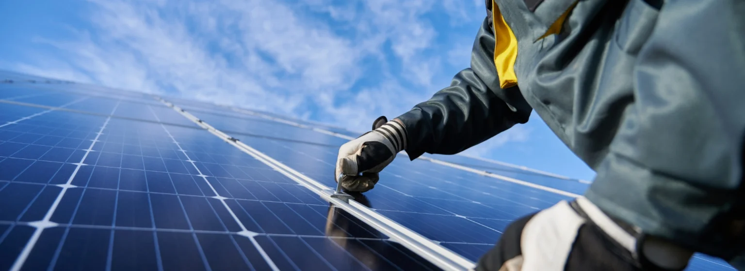 Un ingeniero en paneles solares, colocando módulos fotovoltaicos en un techo